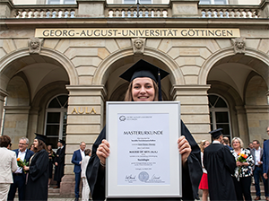 Absolventin mit Masterurkunde der Universität Göttingen vor der Aula-1