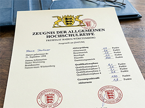 Beschreibend Muster eines baden-württembergischen Abiturzeugnisses auf einem Holztisch-1