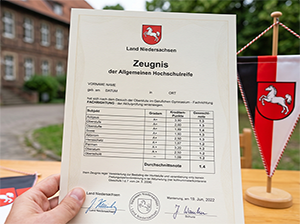 Ein niedersächsisches Abiturzeugnis vor einer Schule-1