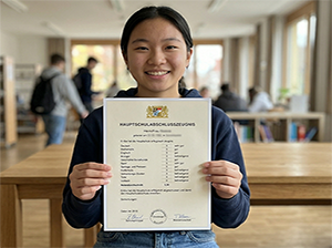 Eine stolze Schülerin mit ihrem Hauptschulabschlusszeugnis-1