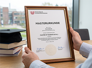 Masterurkunde der Universität Bremen in einem edlen Holzrahmen auf einem Schreibtisch-1