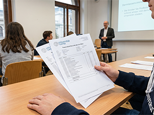 Student mit seinem Transcript of Records der Universität Wien im Hörsaal-1